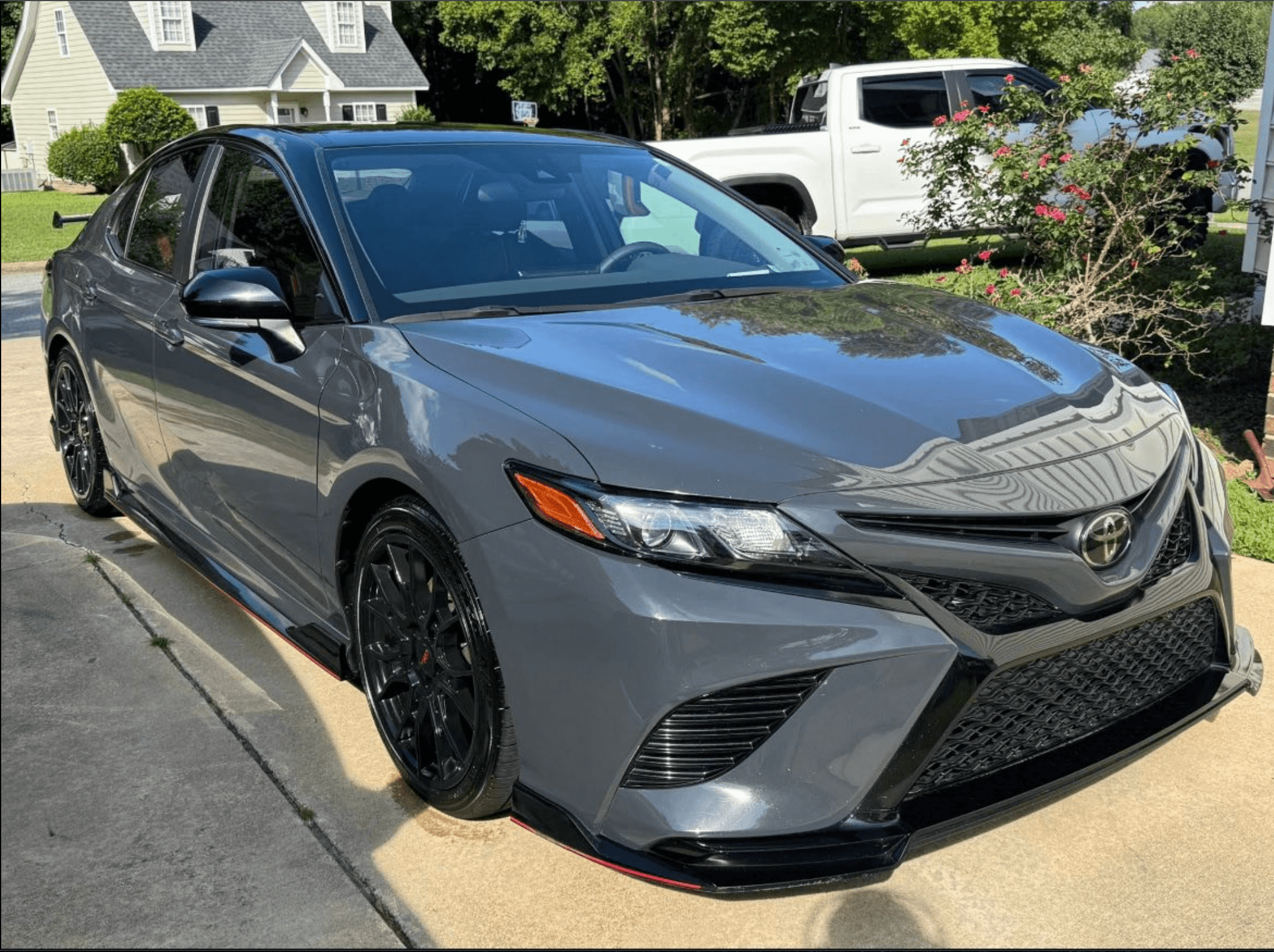 Gray Toyota Camry TRD front three-quarter view in a driveway after a hand wash and carnauba wax