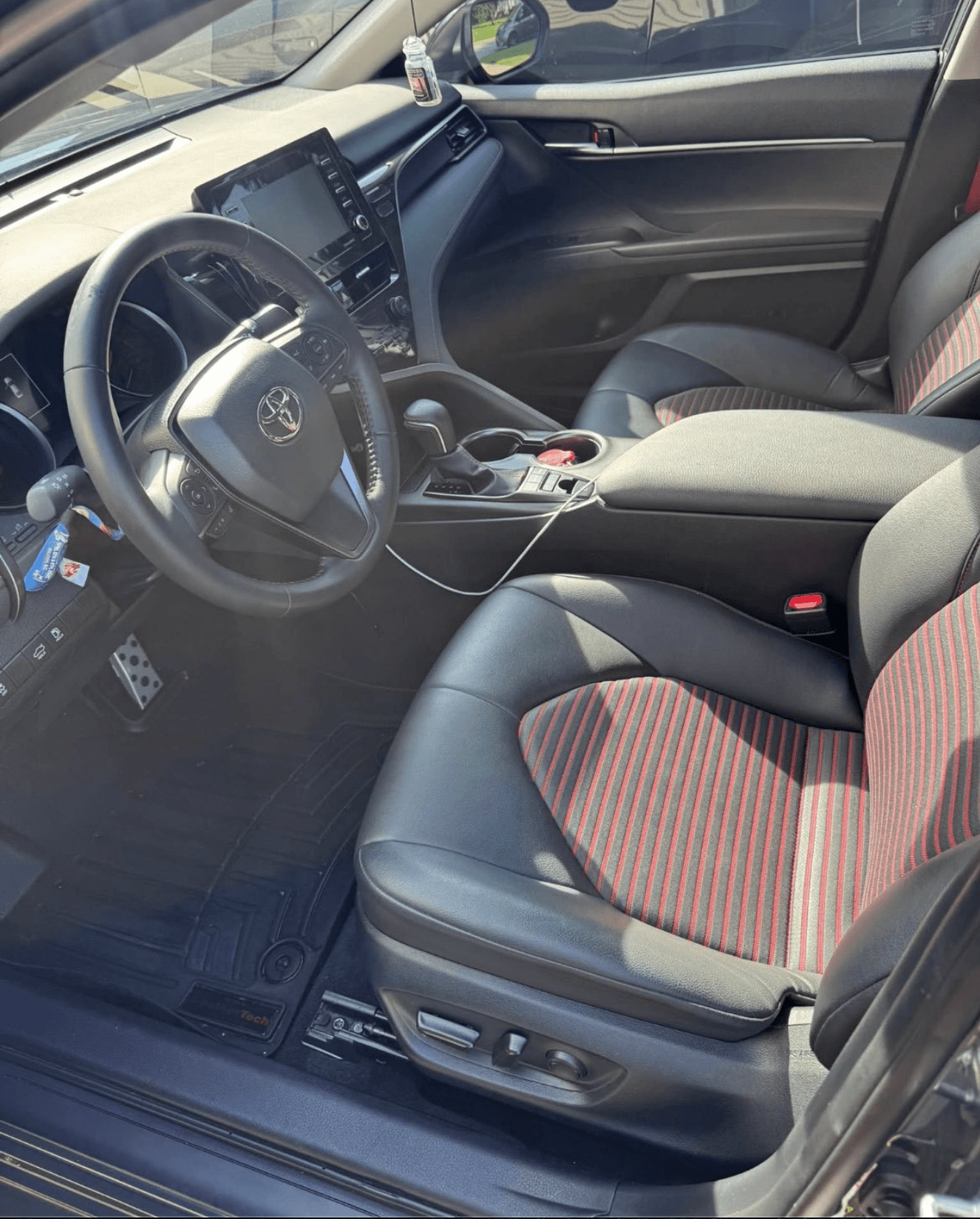 Cleaned driver-side interior of a Toyota Camry TRD with red-and-black sport seats and detailed dashboard