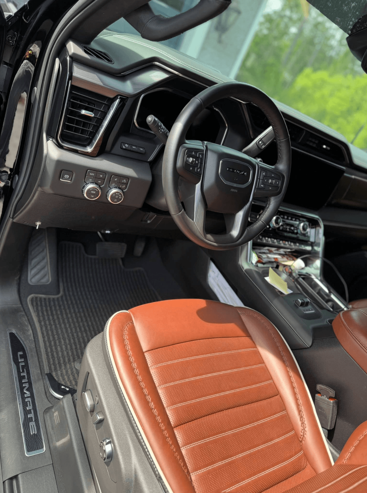 Interior of a GMC Sierra Ultimate truck with cognac leather seats and a detailed dashboard after a full clean